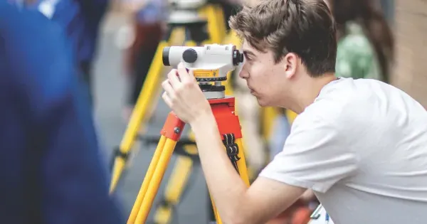 Image of student using a surveying tool. 